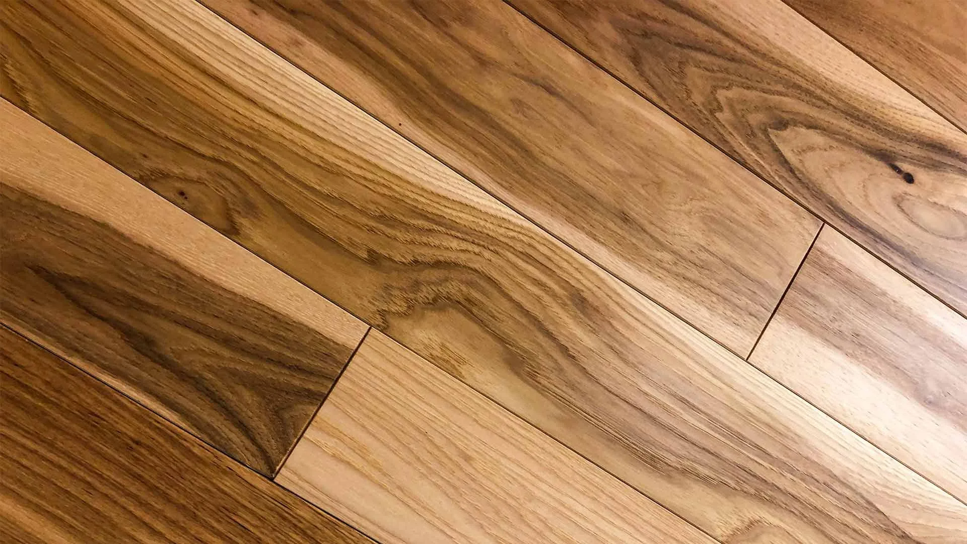 Newly installed natural hardwood flooring planks laid on a diagonal